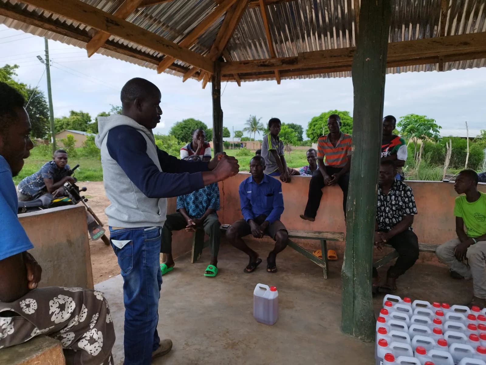Saheed Ibrahim explaining Tokyo8 application to a group of farmers under a community shelter